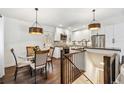 Open-concept kitchen with stainless appliances, white cabinets, and a cozy breakfast nook at 94 Spring Ln, Boulder, CO 80302