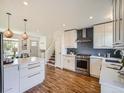 Well-lit kitchen with white cabinetry, stainless steel appliances, subway tile backsplash, and island at 9430 Carr St, Westminster, CO 80021