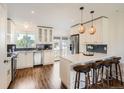 Bright kitchen featuring white cabinetry, stainless steel appliances, and a stylish island with seating at 9430 Carr St, Westminster, CO 80021