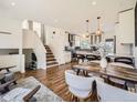 Inviting open-concept living space with modern kitchen, dining area, staircase, and stylish decor at 9430 Carr St, Westminster, CO 80021