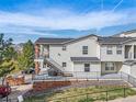 View of townhouses with balconies, stairs, brick accents, and green space at 1646 S Deframe St # B8, Lakewood, CO 80228