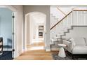Open hallway with hardwood floors, staircase, and neutral walls creating a seamless flow throughout the home at 8122 E 6Th Pl, Denver, CO 80230
