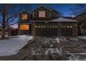 Two-story house with a three-car garage and snow-covered front yard at 2400 S Halifax Way, Aurora, CO 80013