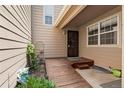 Front porch entrance with wooden deck and black wrought iron security door at 6664 S Webster St, Littleton, CO 80123