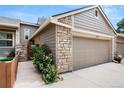Exterior side view of townhome garage with brick accents and walkway at 6664 S Webster St, Littleton, CO 80123