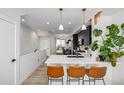 Modern kitchen with white countertops, sleek black cabinets, pendant lights, and a dining area at 4925 W 10Th Ave # 111, Denver, CO 80204
