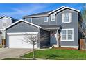 Attractive two-story house featuring a well-manicured lawn and an attached white two car garage at 317 Bonanza Dr, Erie, CO 80516