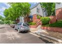 Charming townhome showcasing brick accents, mature trees, and lovely landscaping at 1030 Jersey St # 1, Denver, CO 80220