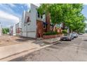 Rear of the property featuring garages, extra parking, and mature landscaping at 1030 Jersey St # 1, Denver, CO 80220