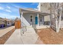 Inviting front porch with a striking blue door and freshly painted railings at 1267 Quitman St, Denver, CO 80204