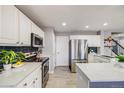 Modern kitchen with white cabinets, stainless steel appliances, and sleek countertops at 5559 S Quemoy Cir, Aurora, CO 80015