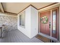 Inviting front porch with stone accents and a decorative wreath on the front door at 1386 Avgare Way, Erie, CO 80516