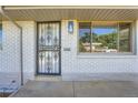 Charming home featuring a secure wrought iron door and beautiful white brick exterior at 1926 S Yates St, Denver, CO 80219