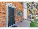 Close-up of townhouse entrance with black security door, white trim, and muted blue shutters at 13977 E Bails Pl, Aurora, CO 80012