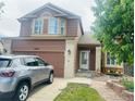 Two-story home with brick accents, attached garage, with a well-kept lawn and front porch at 20410 Kelly Pl, Denver, CO 80249