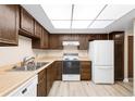 Classic kitchen with white appliances, laminate countertops, and dark wood cabinetry at 14091 E Marina Dr # 308, Aurora, CO 80014