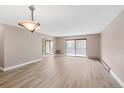 Open-concept living area featuring wood-look floors and sliding glass doors to the balcony at 14091 E Marina Dr # 308, Aurora, CO 80014