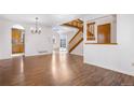 Open floor plan showcasing hardwood floors, modern lighting, a wooden staircase and a large glass patio door at 3948 S Halifax St, Aurora, CO 80013