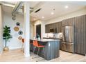 Modern kitchen boasts stainless steel appliances, wood cabinets, an island, and stylish pendant lighting at 3198 Blake St # 402, Denver, CO 80205