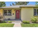 Close-up view of a home's inviting red front door and well-kept landscaping at 4111 S Delaware St, Englewood, CO 80110