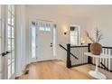 Bright foyer with hardwood floors, decorative sidelights, and a stylish table and railing at 668 Leafy Aster Ln, Castle Rock, CO 80104
