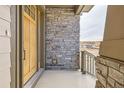 Inviting front porch with stone detailing and wood accents, adding a touch of elegance to the home's entrance at 668 Leafy Aster Ln, Castle Rock, CO 80104