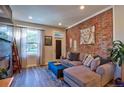 Inviting living room featuring a stylish exposed brick wall and comfortable seating arrangement at 1739 E Martin Luther King Jr Blvd, Denver, CO 80205