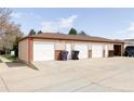 Detached three car garage with white doors and ample parking in the driveway at 5190 E Asbury Ave, Denver, CO 80222