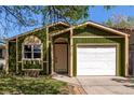 Green single-Gathering home with a white garage door, complimented by lush grass at 1248 Meadow St, Longmont, CO 80501
