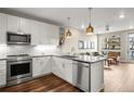 Modern kitchen with white cabinets, stainless appliances, and open layout to living area at 20 Wilcox # 421, Castle Rock, CO 80104