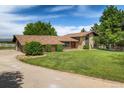 Beautiful home with a well-maintained lawn, mature trees, and a circular driveway at 2117 Stonehenge Cir, Lafayette, CO 80026