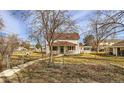 Two-story home featuring a covered front porch and red shutters, set on a spacious lot at 5300 Balsam St, Arvada, CO 80002
