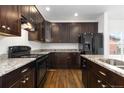 Well-equipped kitchen with dark cabinetry, granite countertops, and modern appliances at 6284 N Genoa Way, Aurora, CO 80019