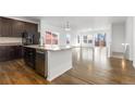 Open-concept kitchen with stainless steel appliances, granite countertops, and a large island at 6284 N Genoa Way, Aurora, CO 80019