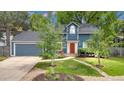Inviting home featuring a blue facade, well-kept lawn, and a vibrant red door at 1304 Ceres Dr, Lafayette, CO 80026