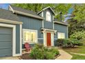 Close-up of a blue house showcasing a red front door, complemented by a well-maintained yard and garden at 1304 Ceres Dr, Lafayette, CO 80026