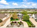 Expansive aerial view of a home with manicured lawns, mature trees, and mountain views in the distance at 2161 Elmwood St, Berthoud, CO 80513