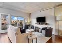 A bright living room with modern furnishings, hardwood floors, and a balcony with city views at 1475 Delgany St # 306, Denver, CO 80202