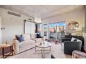 Bright living room with a barn door, hardwood floors, a comfortable sofa and a balcony with city views at 1475 Delgany St # 306, Denver, CO 80202