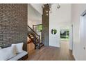 Foyer with stairs, brick accent wall, and wooden floors leading to a room with beautiful backyard views at 5265 W Quarles Dr, Littleton, CO 80128