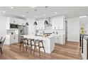 Modern kitchen with white cabinets, stainless appliances, and a large central island at 8242 S Pierson St, Littleton, CO 80127