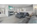 Cozy living room with a fireplace, neutral walls, and plush gray carpeting for comfort at 13802 Jasmine St, Thornton, CO 80602