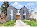 Beautiful modern house with a gray facade, an eye-catching natural wood door, and manicured landscaping at 2961 S Cherokee, Englewood, CO 80110