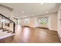 Open floor plan with hardwood floors, large windows offering scenic views, and modern staircase at 12196 W Belleview Dr, Littleton, CO 80127