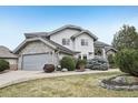 Charming two-story home features stone accents, an attached garage, and a well-manicured lawn at 2247 Eagles Nest Dr, Lafayette, CO 80026