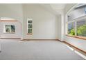 Spacious living room with large windows, neutral walls, and vaulted ceiling at 2247 Eagles Nest Dr, Lafayette, CO 80026