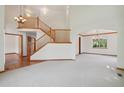 Open-concept room featuring hardwood floors, a staircase, and ample natural light at 2247 Eagles Nest Dr, Lafayette, CO 80026