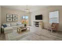Bright living room with modern finishes, neutral colors, and a cozy fireplace at 309 Spruce St, Bennett, CO 80102