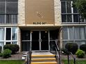 Building 207 entrance featuring glass doors and a well-maintained walkway, flanked by greenery at 3022 S Wheeling Way # 107, Aurora, CO 80014