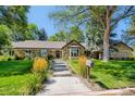Stone home with well maintained lawn, garden and mature trees; a lovely, welcoming view at 13 Club Ln, Littleton, CO 80123